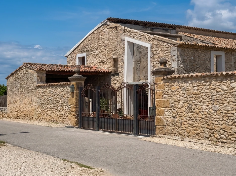 Mas provençal en pierre de taille calcaire, façade rustique avec portail en fer forgé ouvragé à deux vantaux