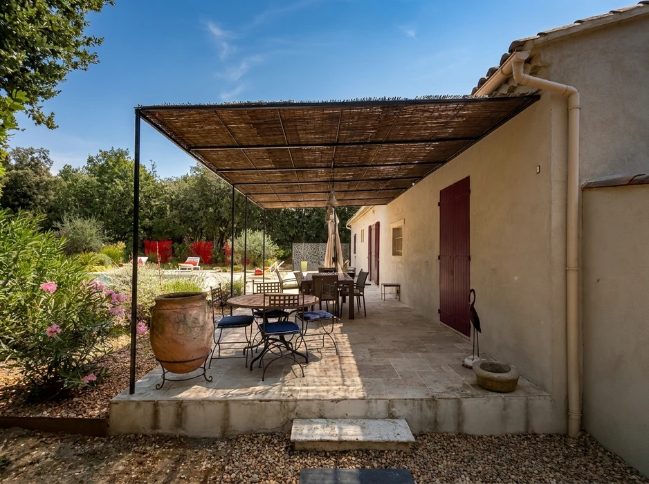 Terrasse couverte provençale avec pergola en métal noir et canisse en roseau